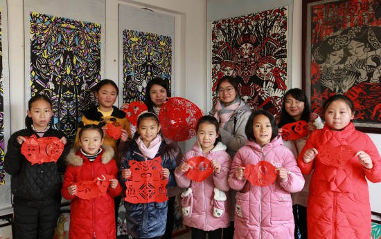 贵州省毕节市黔西县春晖剪纸艺术班的孩子们展示创作的迎春作品.jpg