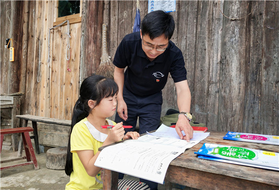 蒋登玉（右）为村里的留守儿童辅导作业.jpg